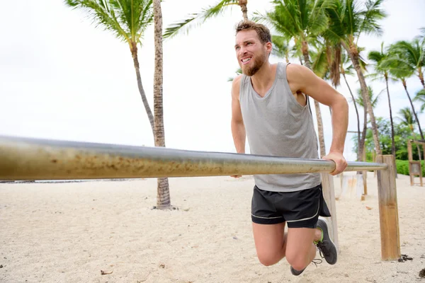 Exercises man workout on dips bars — Stock Photo, Image