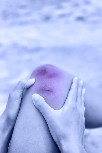 Женщина, держащая колено в боли — стоковое фото