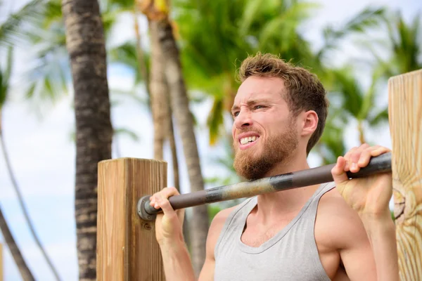 Člověk pracuje pull-up na shyby bar — Stock fotografie