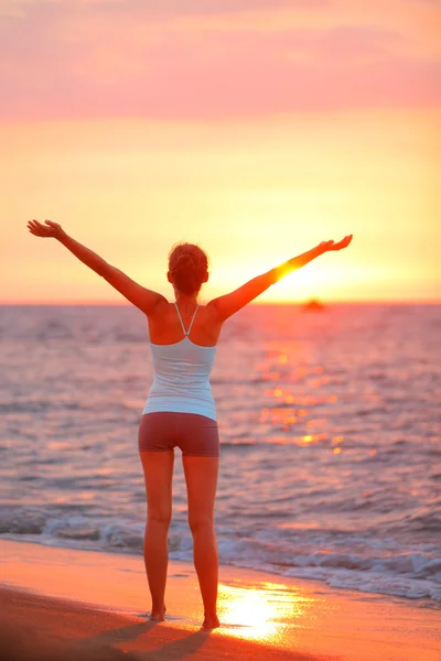 Vrouw ontspannen armen omhoog aan strand — Stockfoto