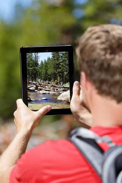 Senderismo hombre tomando fotos de la naturaleza en la tableta —  Fotos de Stock