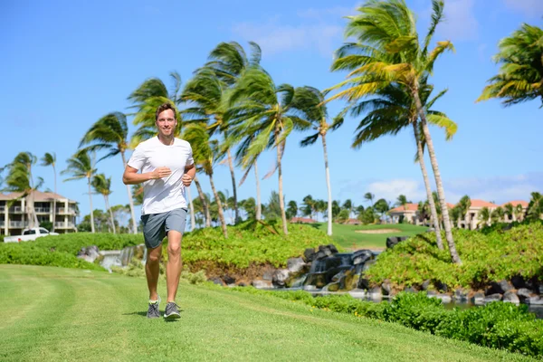 Man running on grass in city park — Stock Photo, Image