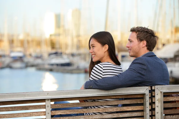 Couple sitting on bench in old harbour — Stock Photo, Image