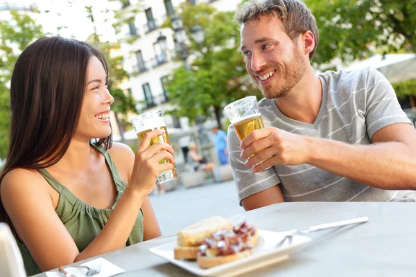 Couple eating tapas drinking beer in Madrid — Stock Photo, Image
