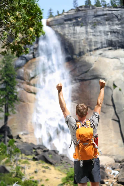 Hiking man cheering by waterfall — Stock Photo, Image