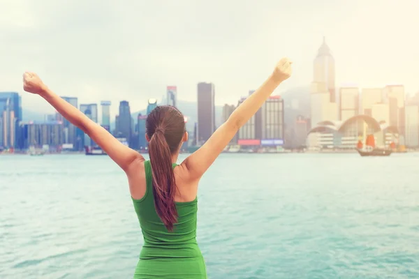 Woman success cheering by Hong Kong city