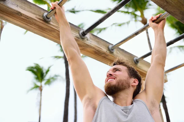 Fitness athlete exercising on monkey bars — Stock Image Fitness athlete exercising on monkey bars Stock Photo