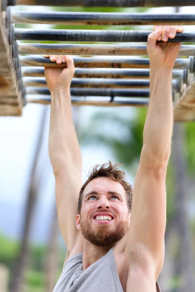Fit man cross training on monkey bars — Stock Image Fit man cross training on monkey bars Stock Picture