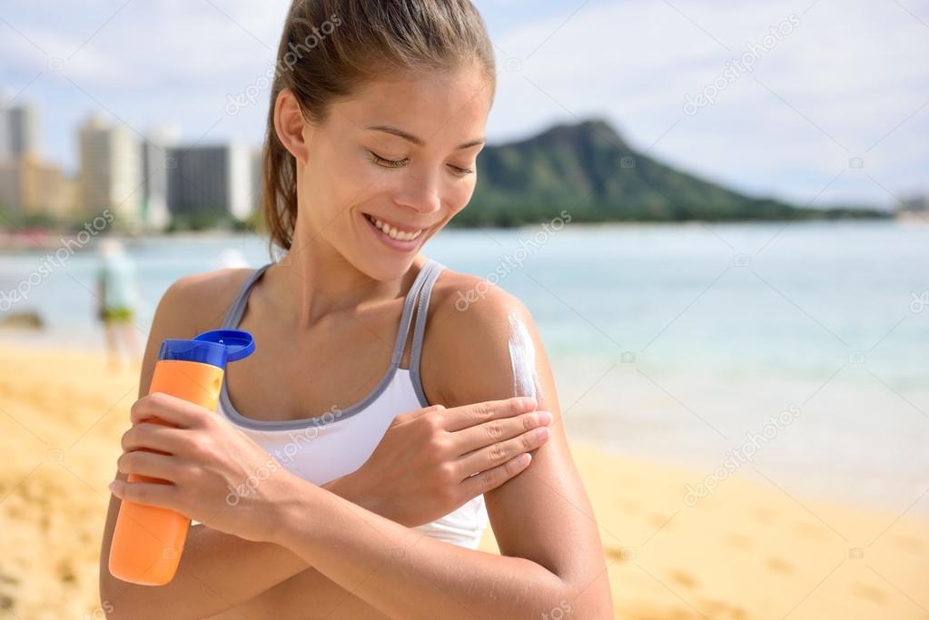 Fitness woman applying suntan lotion Stock Photo by ©Maridav 72655321