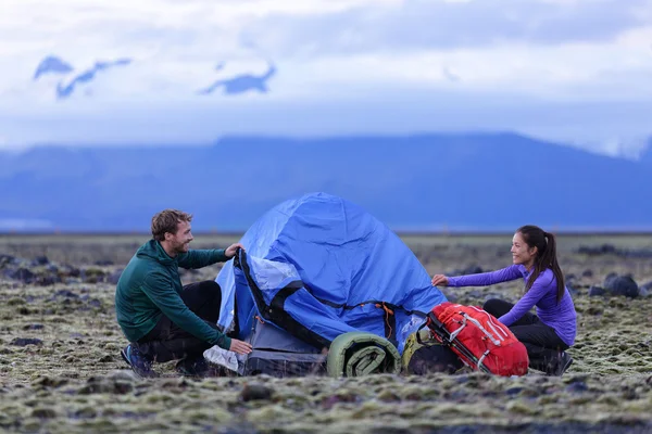 Människor pitching tält på Island i skymningen — Stockfoto