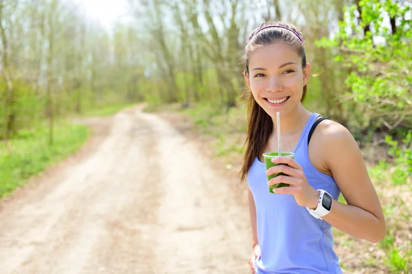 Mujer bebiendo batido usando smartwatch — Foto de Stock