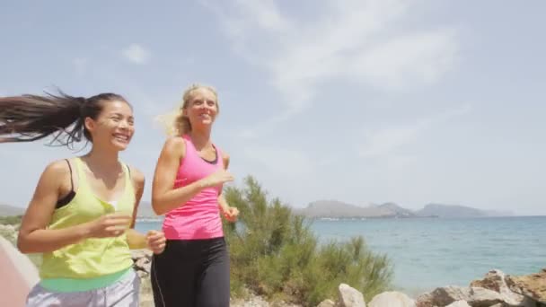 Vrouwen joggen door strand — Stockvideo