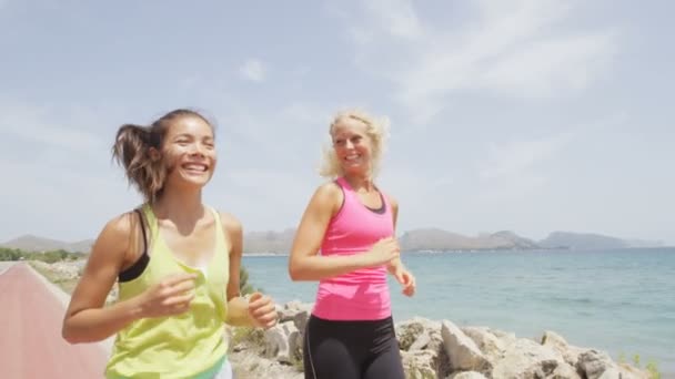 Женщины бегают по пляжу разговаривая — стоковое видео