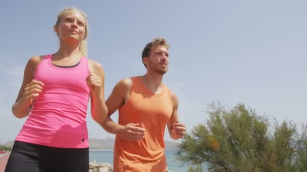 Pareja corriendo en playa boardwalk — Vídeo de stock