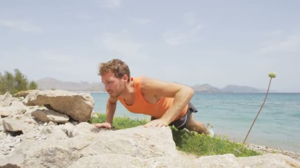 Man doet push ups op rotsen — Stockvideo