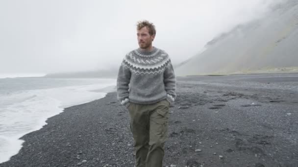 Hombre caminando playa de arena negra en Islandia — Vídeos de Stock