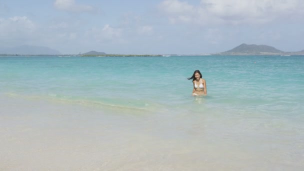 Mujer en la playa caminando fuera del mar en bikini — Vídeos de Stock