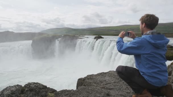 Turista tomando fotos de la cascada Godafoss — Vídeo de stock