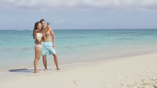 Casal tirando selfie com smartphone na praia — Vídeo de Stock