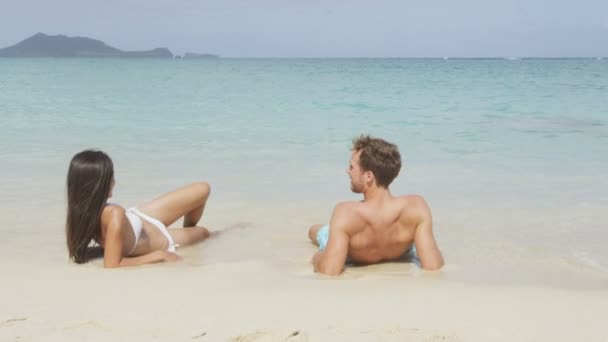 Couple relaxing lying in beach sand — Stock Video