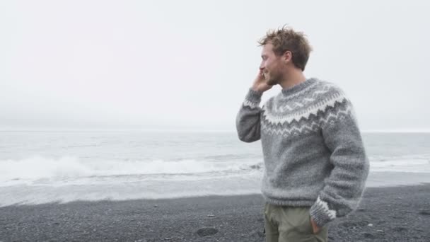 Uomo che parla al telefono sulla spiaggia Islanda — Video Stock