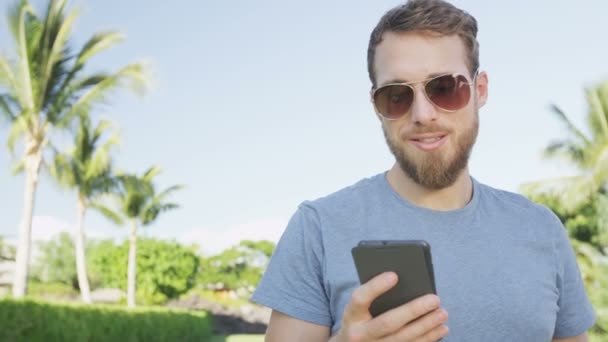 Hombre SMS mensajes de texto en el teléfono inteligente al aire libre — Vídeo de stock