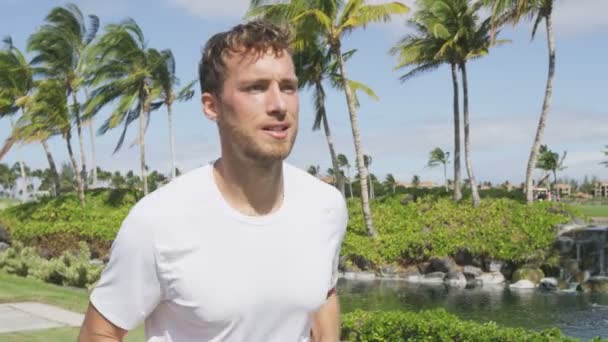 Handsome young man jogging in park — Stock Video