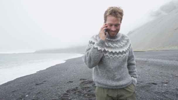 Sahilde yürüyüş smartphone cep telefonu ile konuşan adam — Stok video