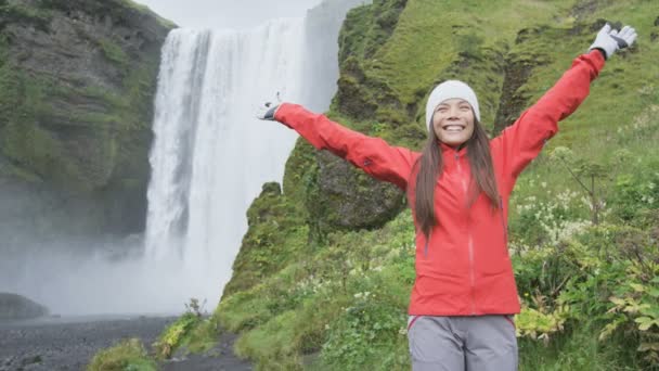 Mujer dichosa por cascada Skogafoss — Vídeos de Stock