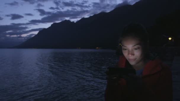 Menina usando smartphone pelo Lago Brienz — Vídeo de Stock