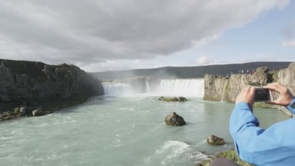 Turista tomando fotos de la cascada Godafoss — Vídeo de stock