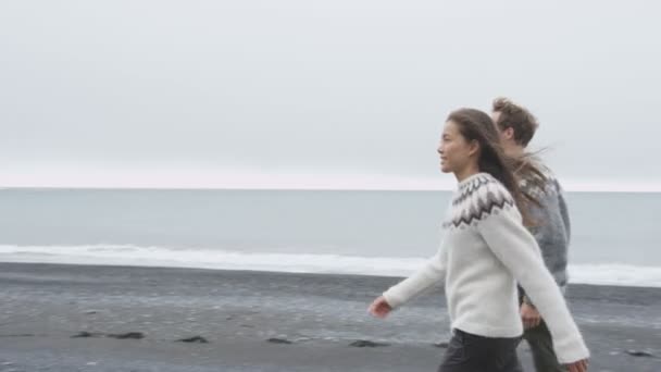 Par bär Isländska tröjor på stranden — Stockvideo