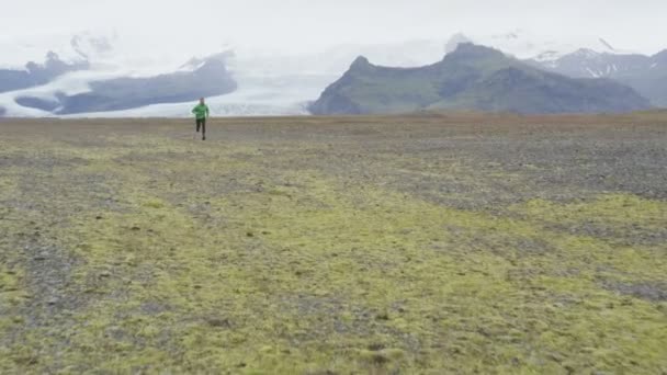 Hombre trotando en el campo de hierba — Vídeos de Stock