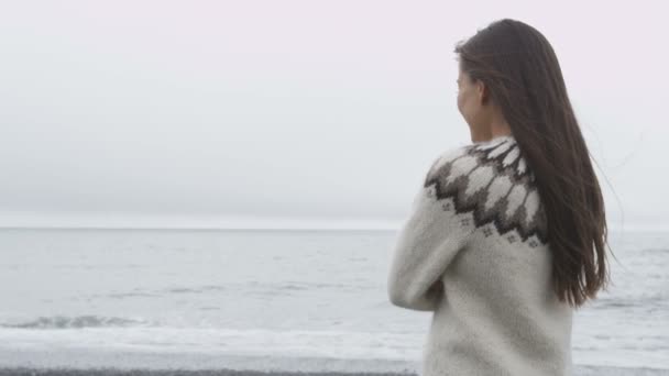 Kvinna som står på stranden på Island — Stockvideo