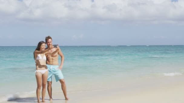 在使用智能手机的海滩上夫妇以自拍照 — 图库视频影像