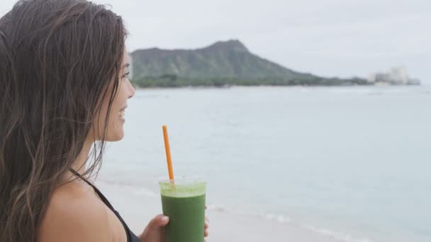 Woman holding juice at beach — Stock Video