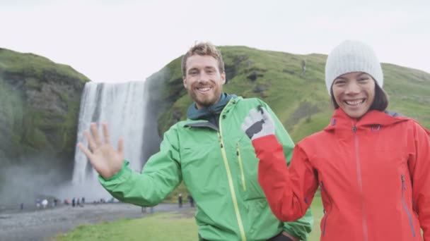 People waving hello with hand by Skogafoss — Stock Video