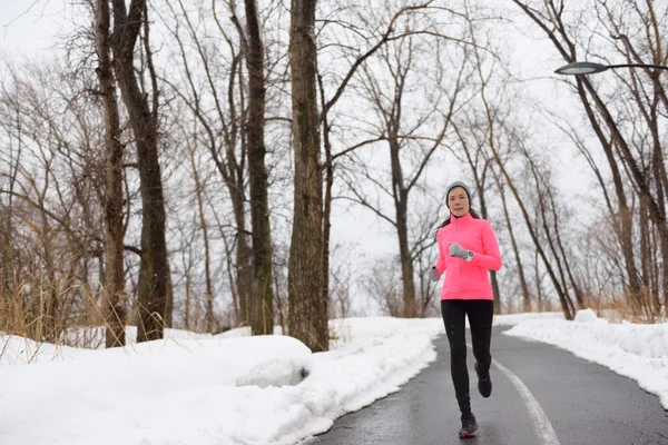 Woman jogging in snowy city park — Stock Fotó