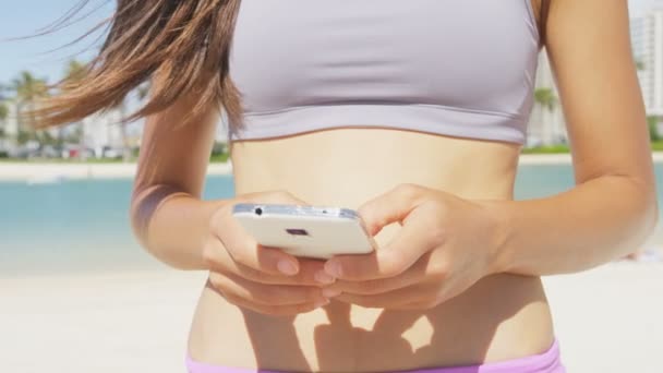 Femme de fitness utilisant un smartphone — Video
