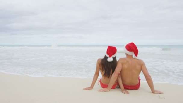 Pareja de Navidad relajándose en la playa — Vídeos de Stock