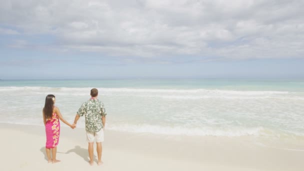 Huwelijksreis paar houden handen op het strand — Stockvideo