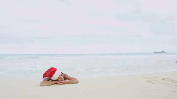 サンタの帽子をかぶったビーチの女性 — ストック動画