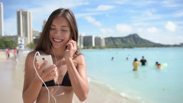 Vrouw op strand luisteren naar muziek — Stockvideo