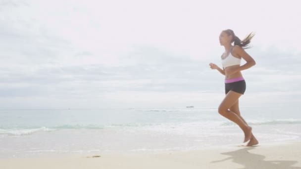 Woman jogging on sea shore. — Stockvideo