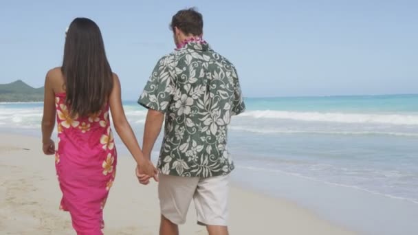 Couple en vêtements Aloha marchant sur la plage — Video