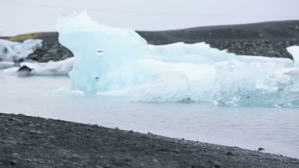 Sporty young man jogging by icebergs — Stock Video