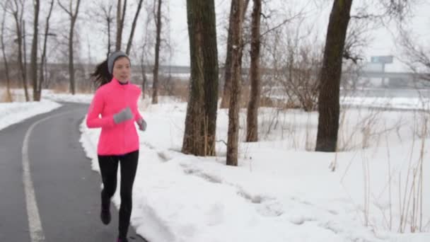 Vältränad kvinna jogging på vägen på vintern — Stockvideo