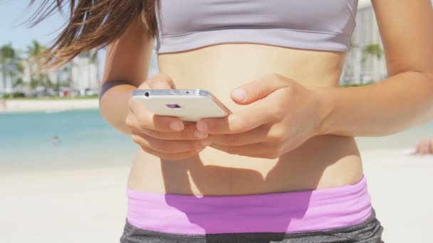 Femme de fitness utilisant un smartphone — Video