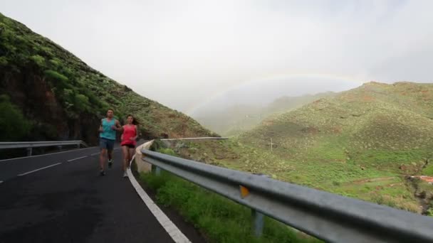 Paar rennen op bergweg — Stockvideo