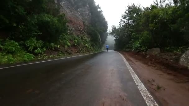 Sportig man som kör på våt landsväg — Stockvideo